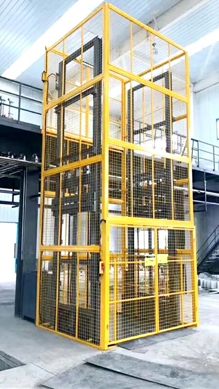 Yellow vertical cargo lift with mesh enclosure